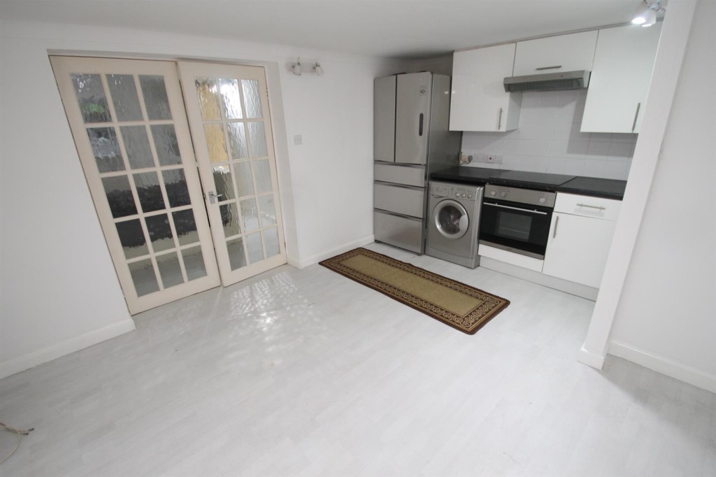Lot: 168 - MID-TERRACE HOUSE FOR IMPROVEMENT - Lower ground floor flat living area with kitchen
